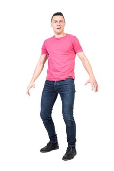 Full body of amazed male model looking at camera with confused face while standing isolated on white background in light studio