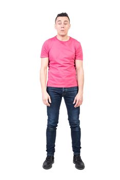 Full body of exhausted sleepy male model in casual clothes woken up early in morning in studio against white background