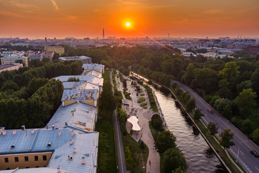 Aerial view of the public park of the Karpovka River Embankment in St. Petersburg at sunset, Russia, recreation areas, benches and amphitheater, botanical garden opposite the park. High quality photo