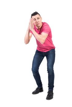 Full length of desperate male with prayer hands supplicating for help and support in studio against white background