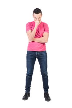 Full body of doubting male model in casual outfit standing with hand at chin and trying to solve problem on white background