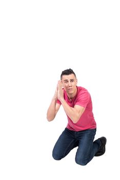 Full body of helpless male sitting on knees and begging for help on white background and looking at camera