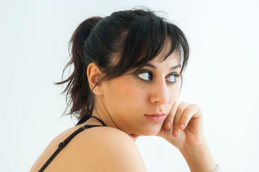 Pretty brunette girl with pigtail looking sideways, on white background, close up