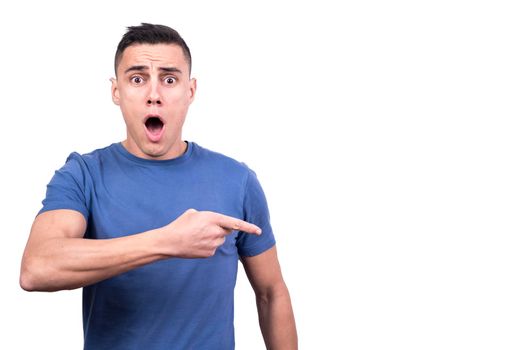 Studio portrait of a man pointing to a side with surprise expression in a white background