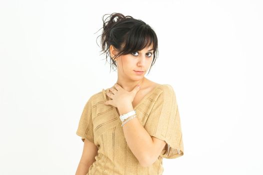 pretty girl looking straight ahead with her hand resting on her neck and collected hair, on white background, medium shot
