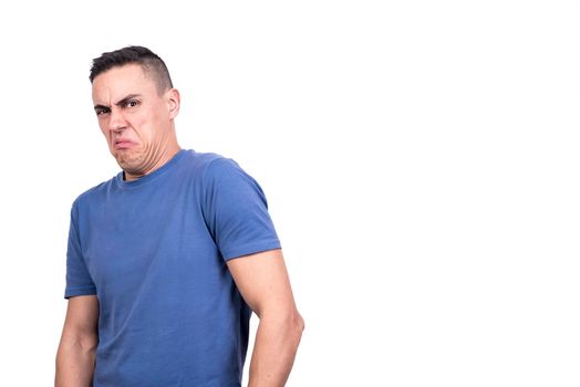 Studio portrait with white background of a man standing while grimacing in disgust