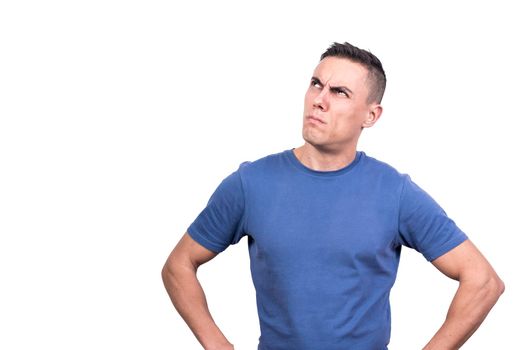 Studio portrait if a man looking up with expression of doubt while thinking with a white background