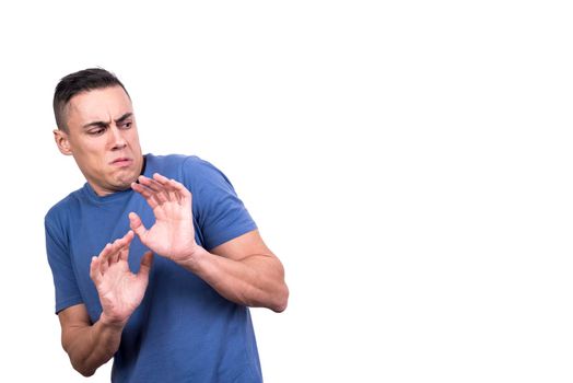 Studio portrait with white background of a man protecting himself with his hands gesturising disgust