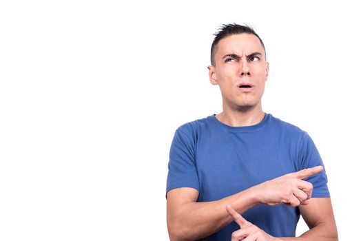 Studio photo with white background of a man pointing to the side with confused expression