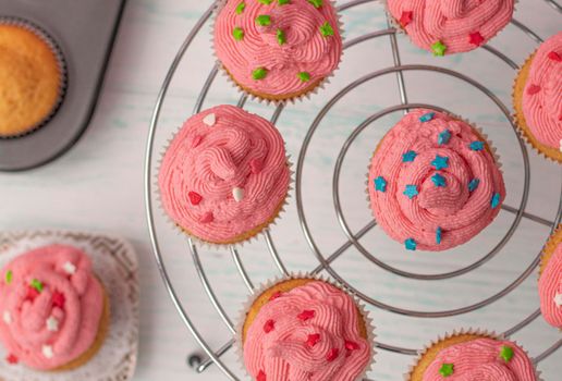 top view, vanilla muffins decorated with cream and sugar multicolored decor. stand in a circle. Homemade baking concept. Beautifully decorated cupcakes with butter cream. High quality photo