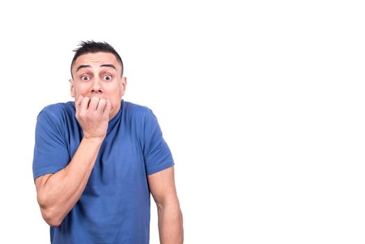 Studio portrait with white background of a man biting his nails with frightened expression
