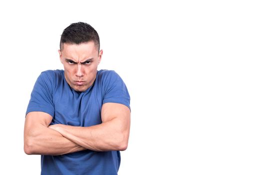 Studio portrait with white background of a man with crossed arms and angry scowl