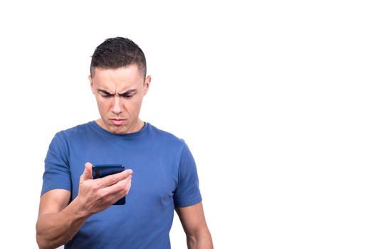 Studio photo with white background of a man looking at the mobile phone with a serious expression
