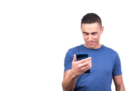 Studio photo with white background of a man looking at the mobile phone while smiling