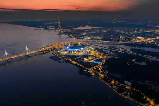 Russia, St. petersburg, 17 August 2022: A picturesque sunset over the sights, the Gazprom Arena football stadium, the highest skyscraper in Europe Lakhta and a cable-stayed bridge, illuminated highway. High quality photo