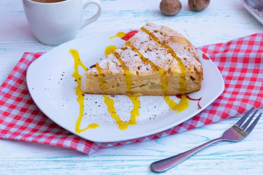 classic homemade apple pie with topping and cinnamon on a plate. A piece for one. Small dessert fork and checkered napkin. Culinary Blog Concert. dessert for tea. Lunch . High quality photo