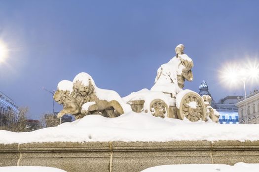 Plaza de la Cibeles in Madrid on a cold winter night after a heavy snowfall.