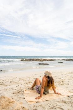 Pretty woman sunbathing on the beach. Long shot. Formentera island, Spain.