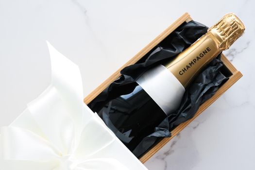 Wedding celebration, lifestyle and luxury present concept - A champagne bottle and a gift box on marble