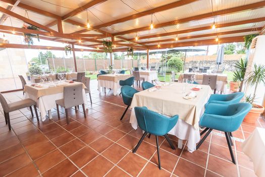 View of the tables arranged and ready for use in the hotel's dining room. Concept of hotel.