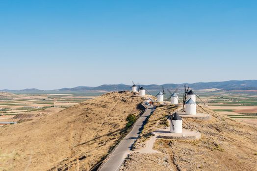 Road in the middle of windmills on the top of a hill in Consuegra, in Toledo, Spain