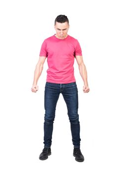 Full length angry male in jeans and pink t shirt clenching fists and looking at camera with frown while starting fight against white background