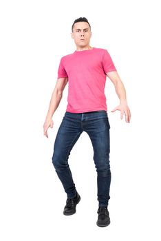 Full body of confused male looking at camera with concerned gaze while standing isolated on white background in light studio