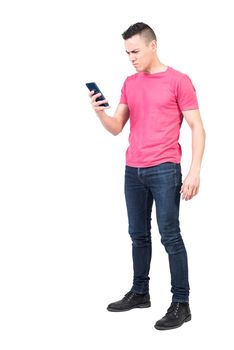 Full body of worried man in casual wear reading bad news on mobile phone while standing against white background
