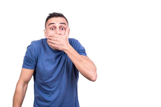 Studio portrait with white background of a man covering his mouth with expression of surprise