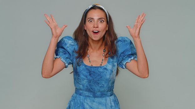 Excited amazed young woman touching her head and showing explosion, looking worried and shocked, professional burnout. Girl looking shocked surprised wow showing hands brain head explosion gesture