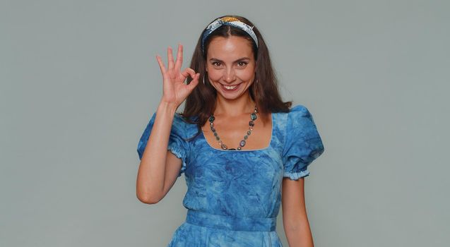 Ok. Lovely pretty young woman looking approvingly at camera showing ok gesture, like sign positive, approve something good. Adult stylish female girl isolated alone on gray studio background indoors