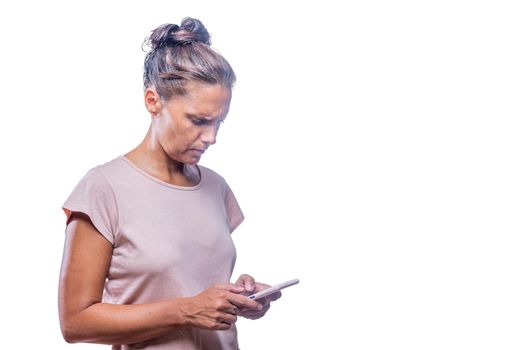 Front view of a green-eyed woman using her cell phone frustrated on a white background with copy space.
