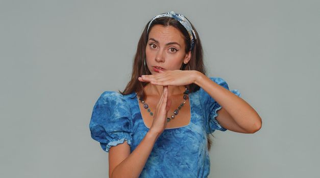 Time out, need a break. Tired serious upset pretty young woman in dress showing pause relax gesture, limit or stop sign. Adult stylish female girl isolated alone on gray studio background indoors