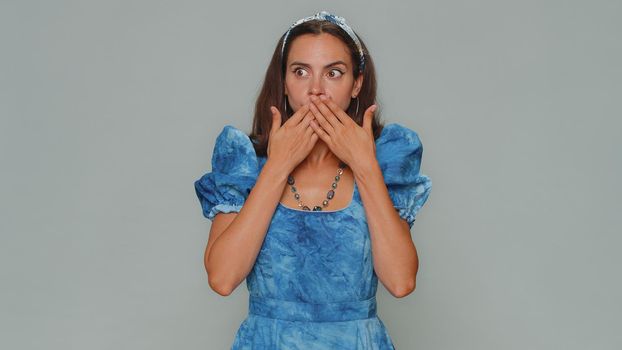I will not say anyone. Frightened young woman closing her mouth with hand, looking intimidated scared at camera, gestures no, refusing to tell terrible secret, unbelievable truth. Adult female girl