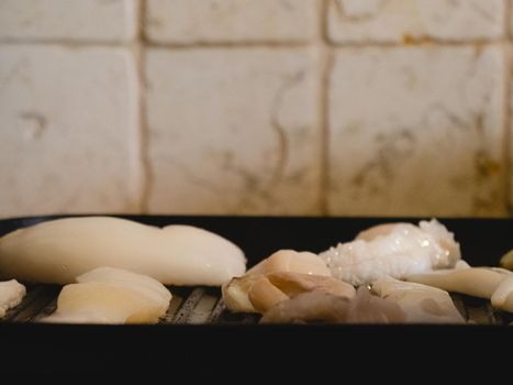 grilling a raw adriatic cuttlefish at home in Numana, Marche, Italy