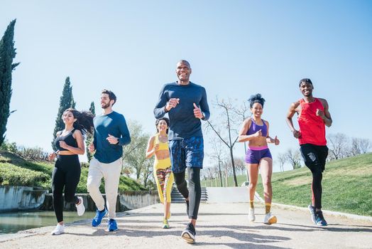 Group of runners training in a park. Front view.