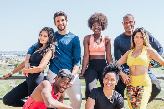 Group portrait of runners smiling at camera. Horizontal framing.