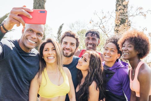 Group of runners taking a selfie in a park. Happy and smiling. Horizontal framing.