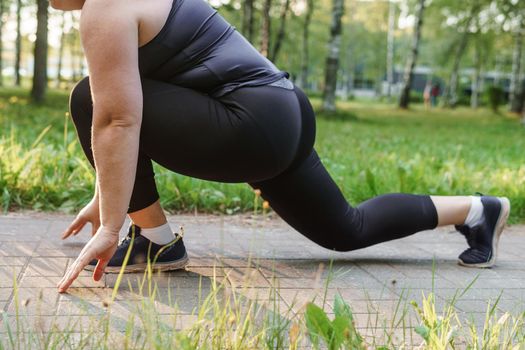A charming brunette woman plus-size body positive practices sports in nature.
