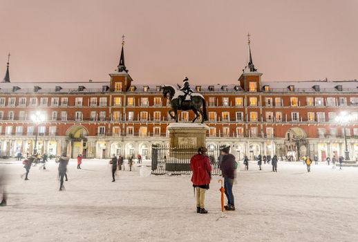 Plaza Mayor in Madrid on a cold winter night after a heavy snowfall.