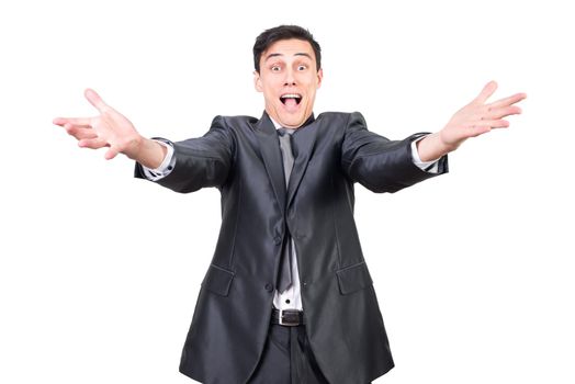 Positive young male entrepreneur with dark hair in classy suit smiling and reaching out arms towards camera against white background
