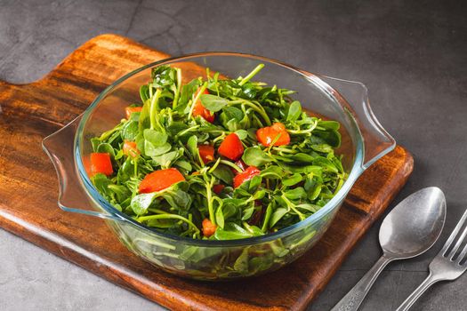 Purslane salad with tomatoes in a glass bowl. Healthy eating concept