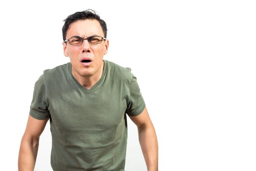 Blind nerdy man in green t shirt and glasses squinting and looking at camera against white background