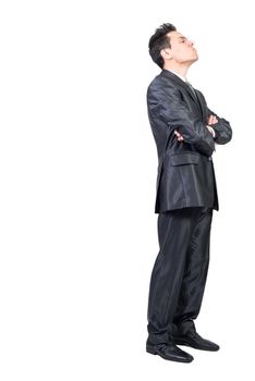 Full body side view of arrogant male entrepreneur wearing formal suit standing with crossed hands and closed eyes on white isolated background