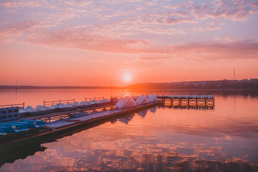 wooden pier with boats at sunset.