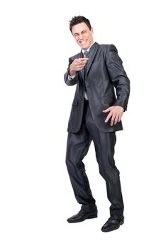 Full body of happy male executive manager pointing at camera and laughing on funny joke in studio against white background