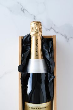 Wedding celebration, lifestyle and luxury present concept - A champagne bottle and a gift box on marble