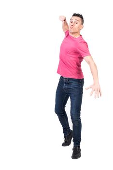 Full body angry man in jeans and pink t shirt looking at camera aggressively and raising clench fist for punch isolated on white background