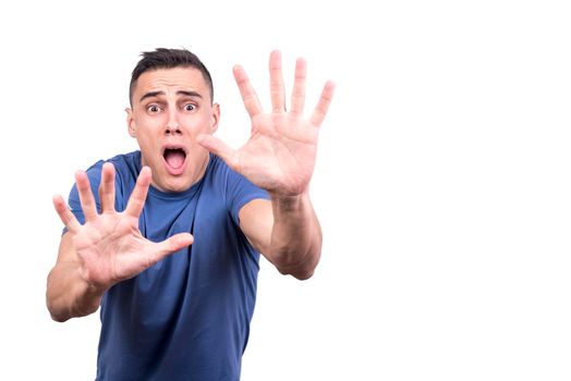 Studio portrait with white background of a man with raising palms as stop sign and a frightened face