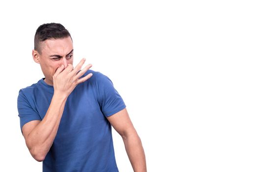 Studio portrait with white background of a man blocking his nose with his fingers due to bad smell